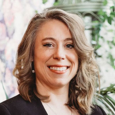 Portrait souriant d'une femme aux cheveux bouclés.