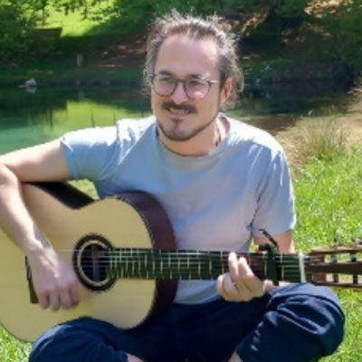 Homme jouant de la guitare en plein air.