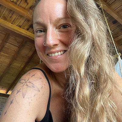 Femme souriante avec de longs cheveux ondulés.