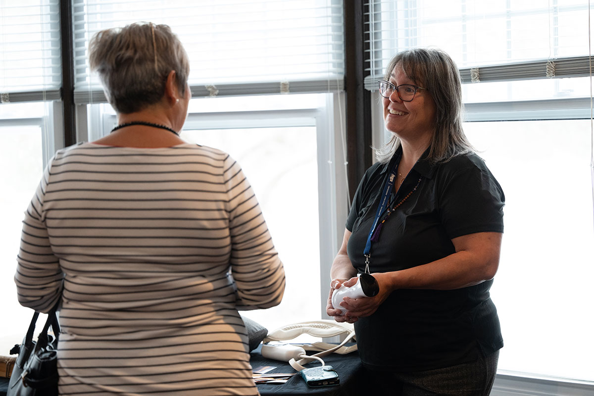 Deux femmes discutent dans un espace lumineux.