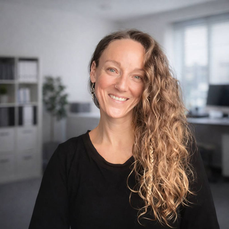 Femme souriante avec des cheveux bouclés.