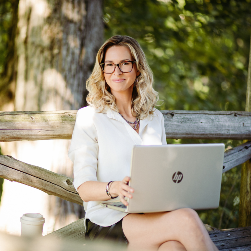 Femme souriante travaillant sur ordinateur portable dans un parc