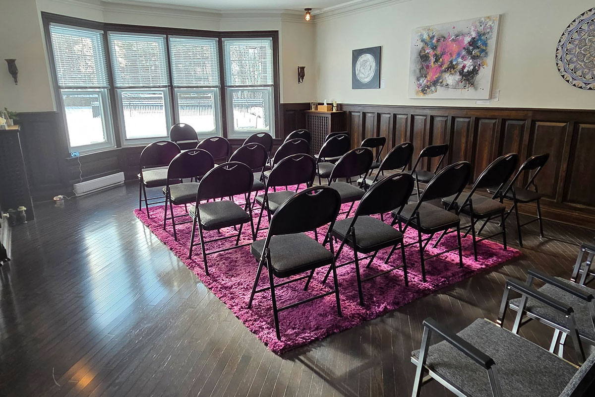 Salle de réunion avec chaises noires sur un tapis.