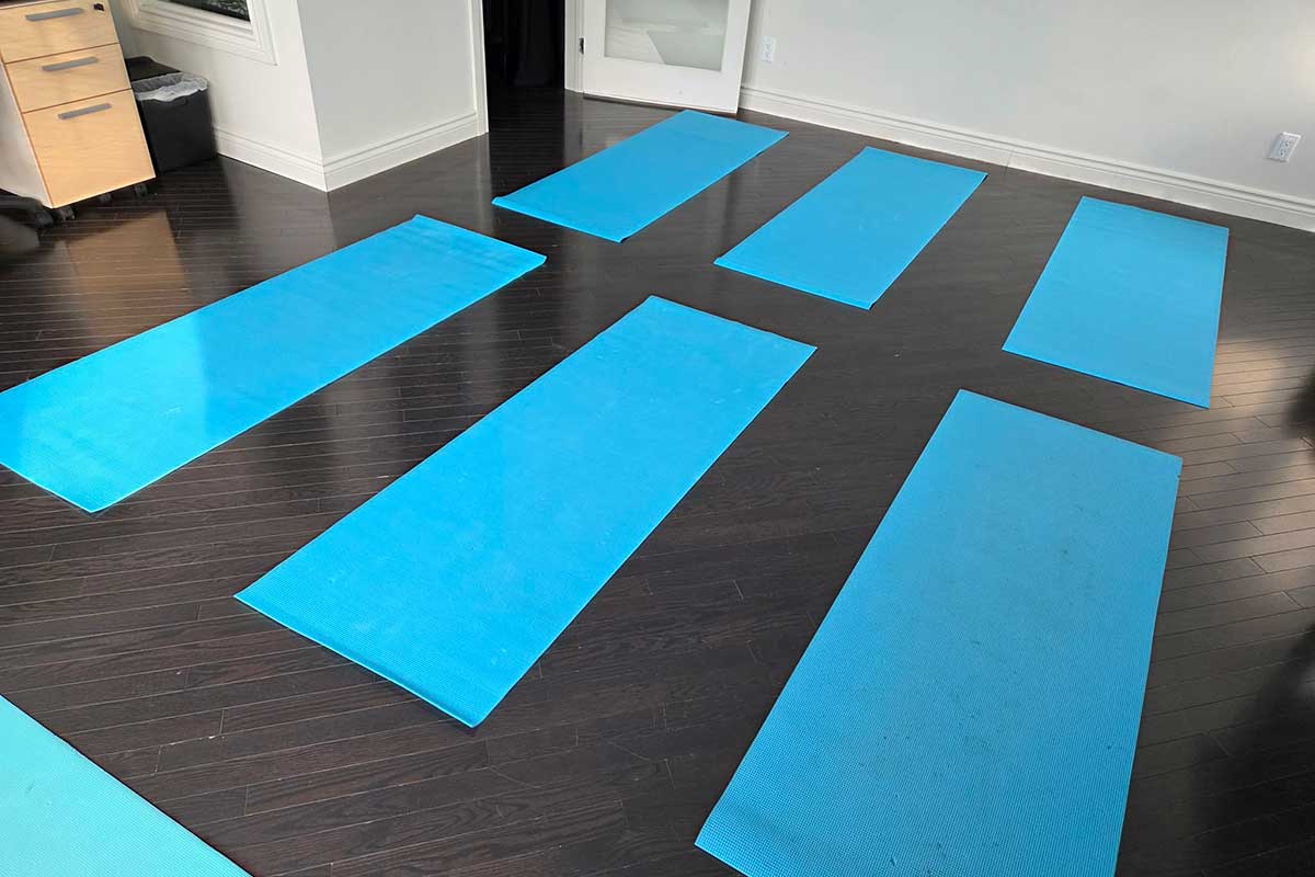 Salles de yoga avec des tapis bleus disposés.