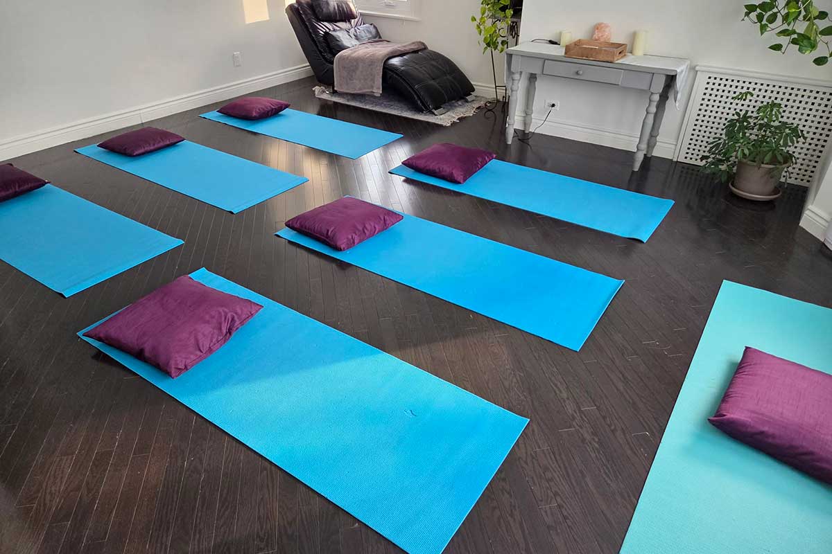 Tapis de yoga bleu avec coussins violets.