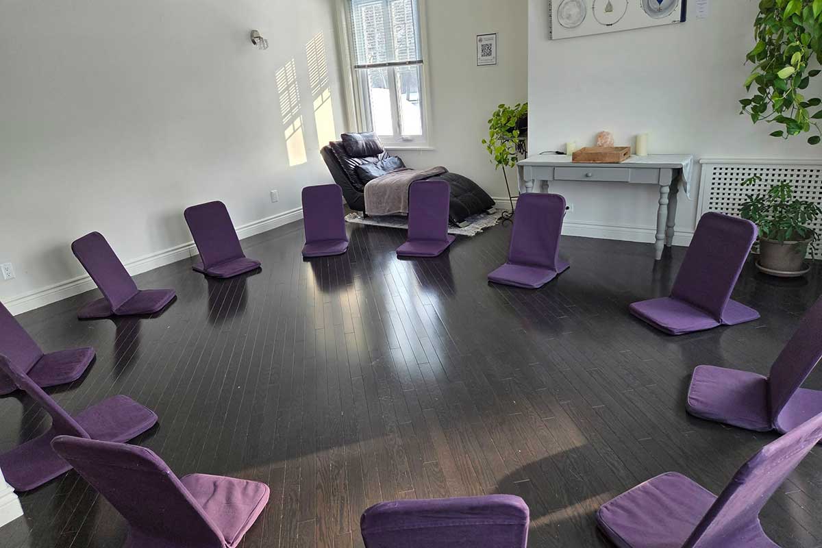 Chaises violettes disposées en cercle dans une pièce.